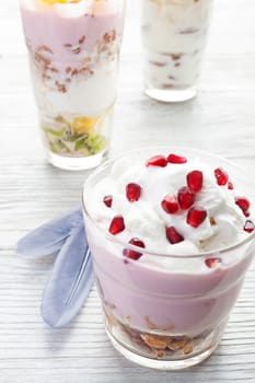 Natural homemade yogurt with fruits on a white wooden background, selective focus