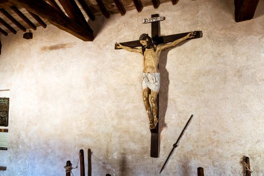 Jesus Christ on the cross statue in an ancient medieval chapel