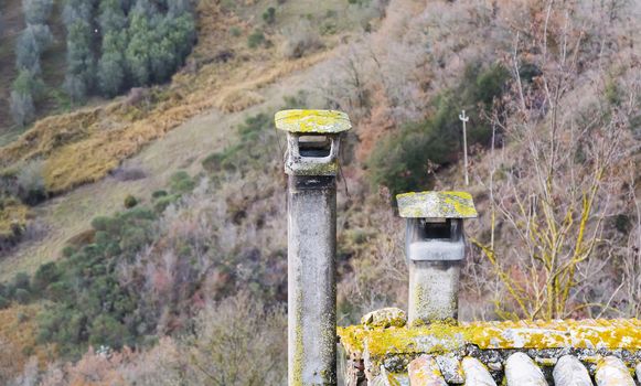 a pair of two old ruined chimneys with moss