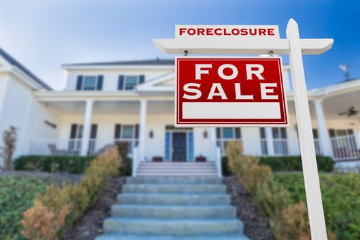 Left Facing Foreclosure For Sale Real Estate Sign in Front of House.