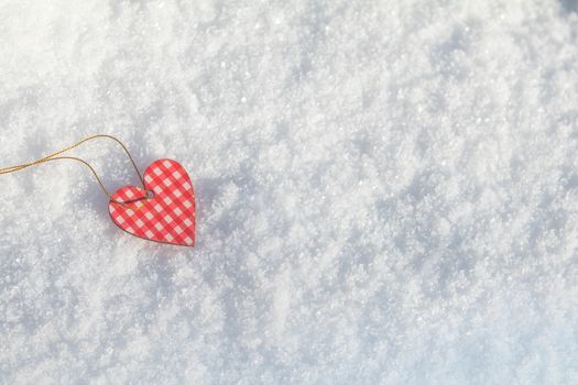 Beautiful valentine holiday background with checkered motley heart on white snow surface.