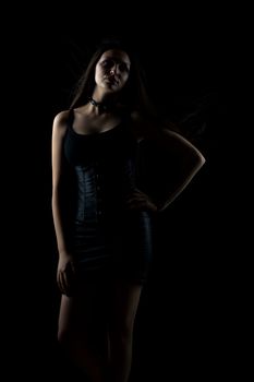portrait of young sexy girl with long hair on dark background in studio, goth style