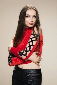 gothic style girl posing in studio wearing a red shirt and black short dress