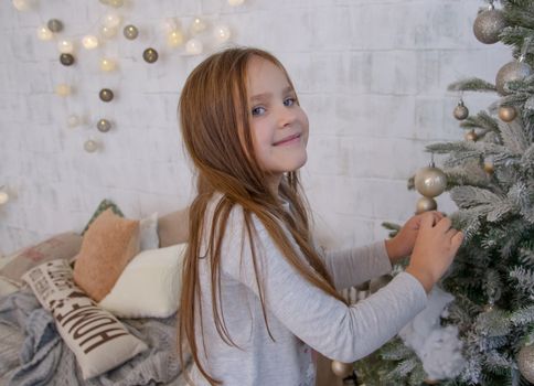 Girl decorating Christmas tree with balls