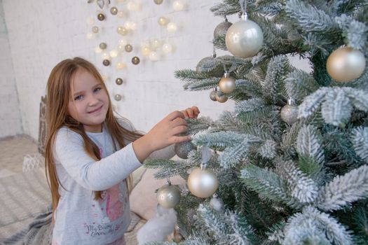 Girl decorating Christmas tree with balls