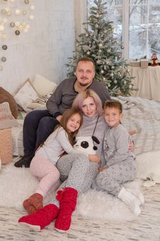 Happy family with two children under Christmas tree