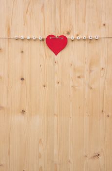 The german words for all love and a heart on a cord on wood