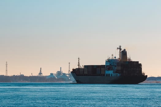 Modern black container ship moving from Baltic sea