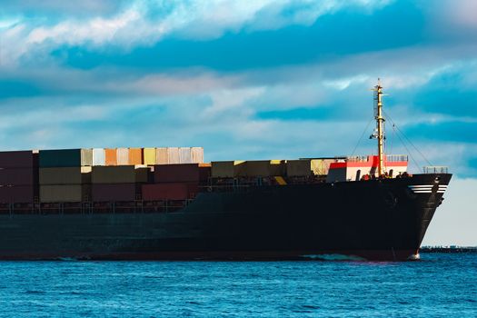 Modern black container ship moving from Baltic sea