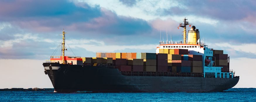 Modern black container ship moving from Baltic sea