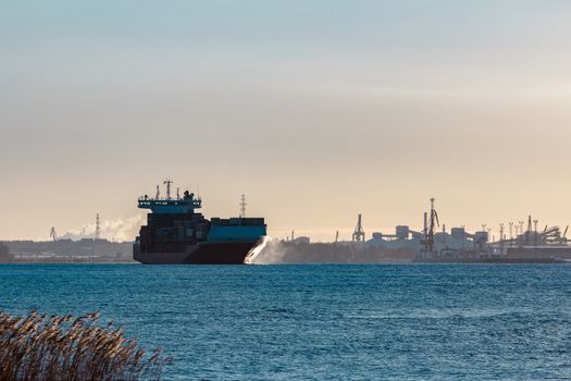 Full red container ship moving in still water
