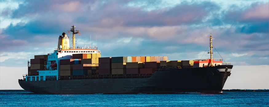 Modern black container ship moving from Baltic sea