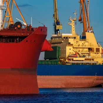 Red and blue cargo ship loading in the port of Riga