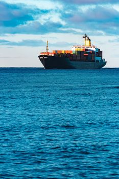 Modern black container ship moving from Baltic sea