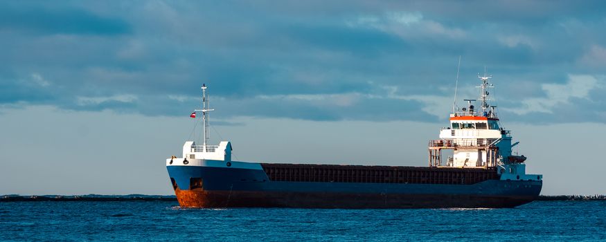 Blue bulk carrier sailing in still water