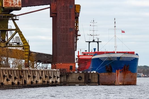 Blue cargo ship loading in the port of Riga, Europe