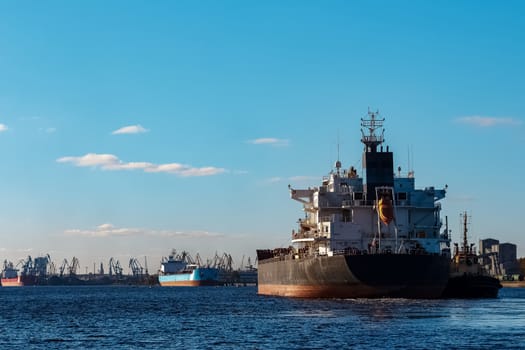 Black cargo ship entering the port of Riga, Europe