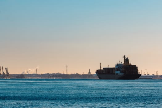 Modern black container ship moving from Baltic sea