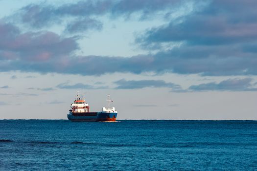 Blue bulk carrier sailing in still water