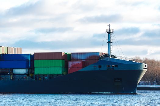 Modern grey container ship moving in still water