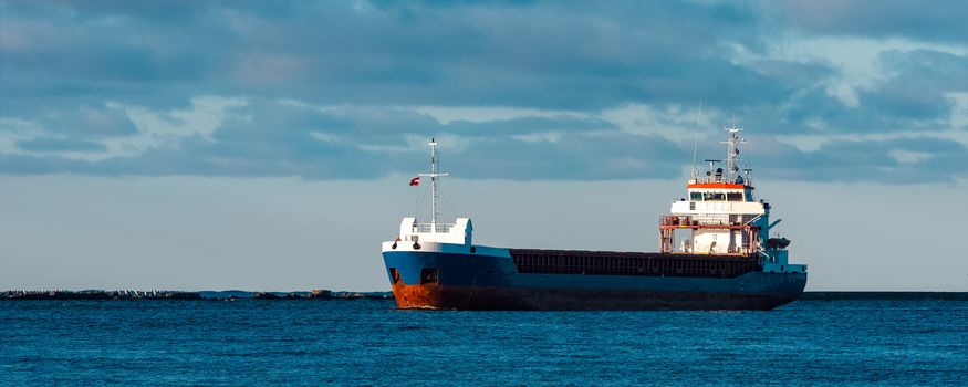 Blue bulk carrier sailing in still water