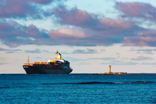Modern black container ship moving from Baltic sea