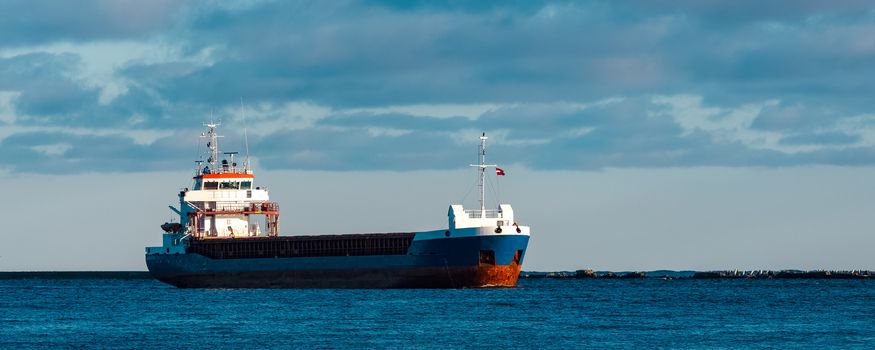 Blue bulk carrier sailing in still water