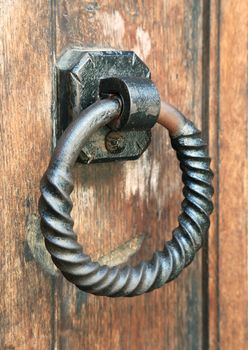 Metal ring door knocker on a medieval wooden door