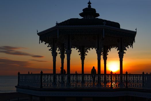 BRIGHTON, EAST SUSSEX/UK - JANUARY 26 : View of the sunset from a bandstand in Brighton East Sussex on January 26, 2018. Unidentified people.