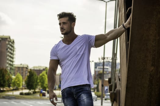 Attractive man in urban setting in front of big metal structure