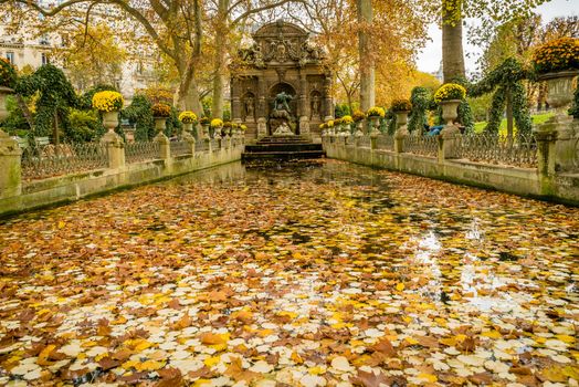 Medici fountain in Jardin du Luxembourg in France, in autumn covered with leaves
