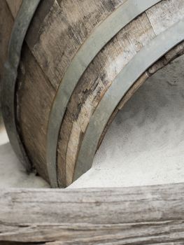 An old wooden barrel lies in the sand