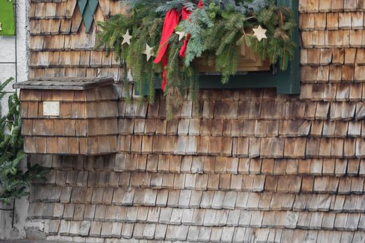 A mailbox on the wall with wooden shingles