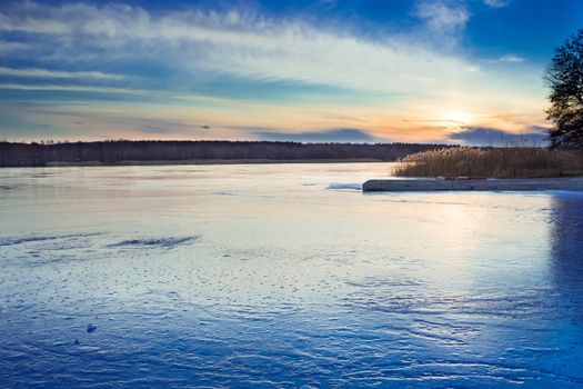 Winter paysage landscape of sunset evening iced frozen lake river