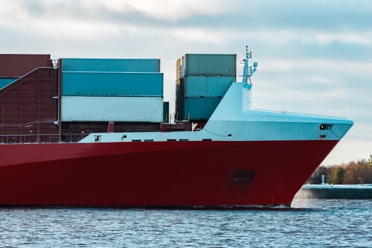 Full red container ship moving in still water