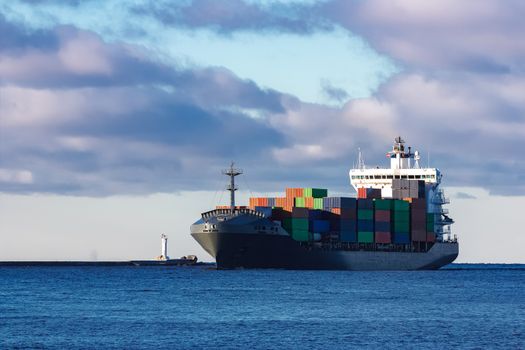 Modern grey container ship moving in still water