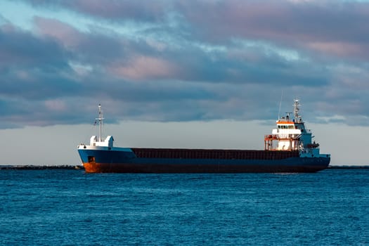 Blue bulk carrier sailing in still water