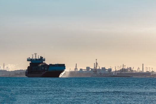 Full red container ship moving in still water