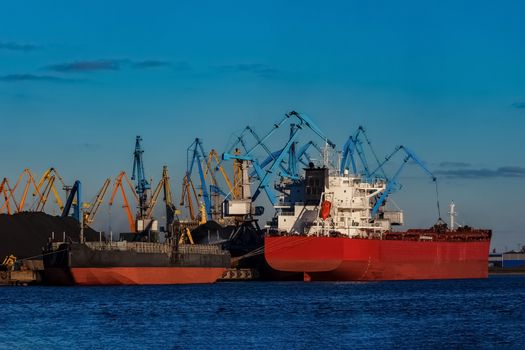 Red cargo ship loading in the port of Riga, Europe
