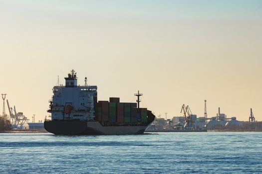 Modern grey container ship moving in still water
