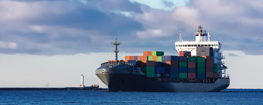 Modern grey container ship moving in still water