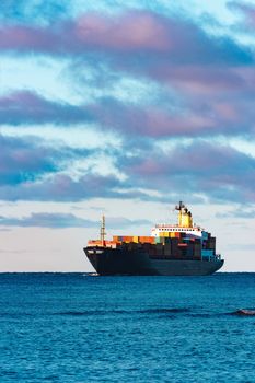 Modern black container ship moving from Baltic sea