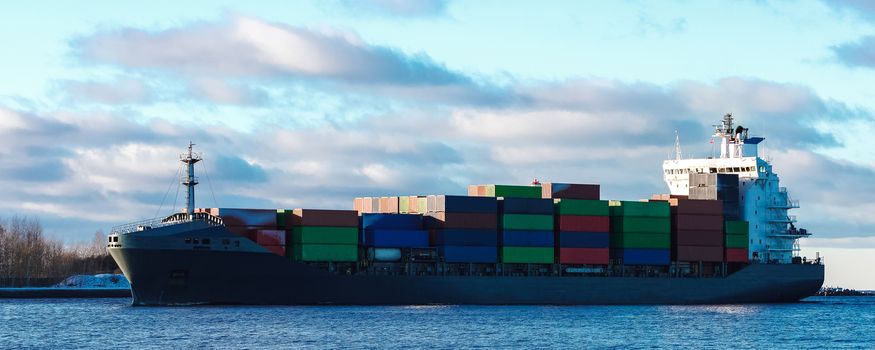 Modern grey container ship moving in still water