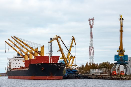 Black cargo ship loading in the port of Riga, Europe