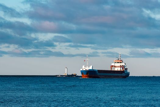 Blue bulk carrier sailing in still water