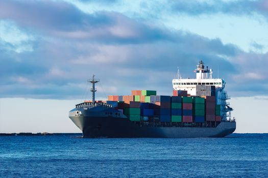 Modern grey container ship moving in still water