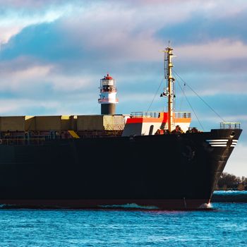 Modern black container ship moving from Baltic sea