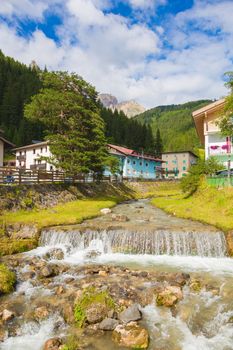 mountain river flowing through village in the Alps