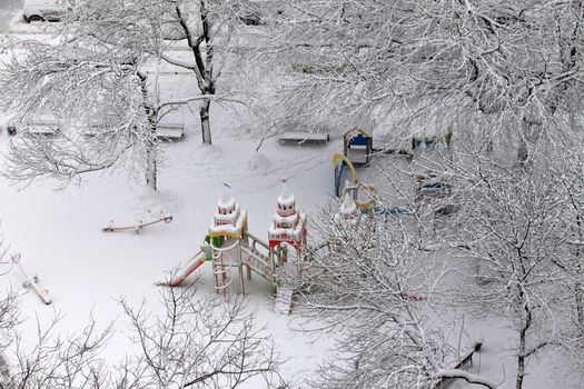 Deserted children's playground covered with snow