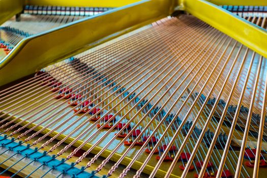 Close up of an antique grand piano showing the sounding board and strings.